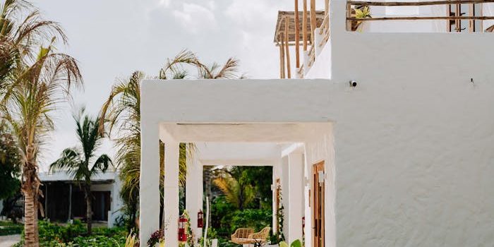 Sunny view of a beachfront villa in Jambiani with lush greenery and palm trees.