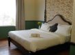 Spacious hotel bedroom with a neatly made bed, decorative headboard, and fresh linens, offering a relaxing atmosphere in a luxurious Palm Leisure resort.