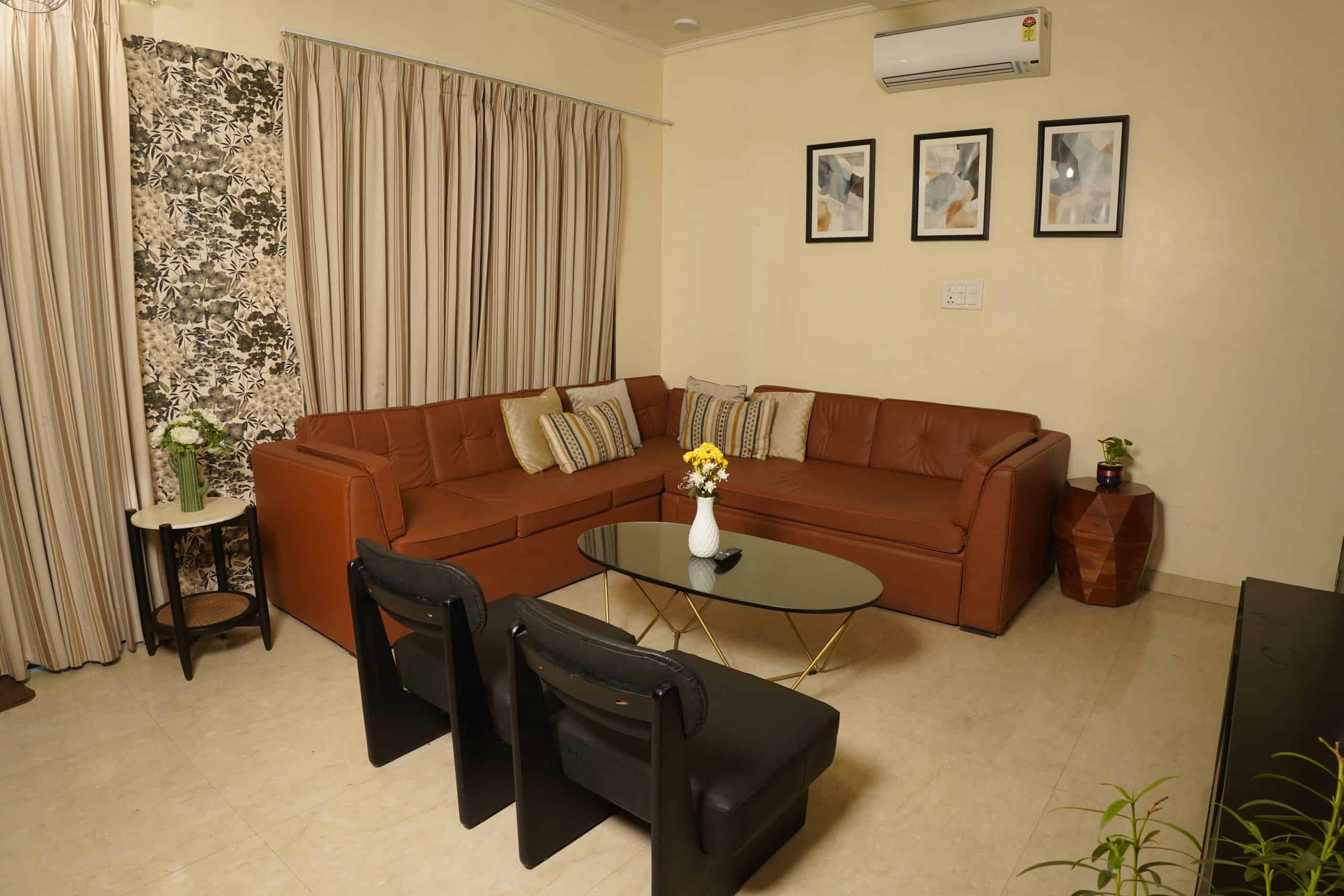 Cozy living room with modern decor, featuring a large brown sectional sofa, contemporary wall art, and stylish furniture, perfect for relaxing at Palm Leisure resorts.